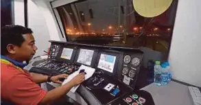  ??  ?? Kapten Mohd Rosmadi Abdul Hadi memandu tren MMMSL.