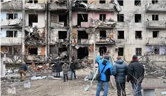  ?? ?? Buildings in Kyiv's suburbs were hit by military fire on February 24, hours after a cyber attack disrupted internet connection­s in Ukraine
