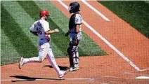  ?? SCOTT KANE/AP ?? The Cardinals’ Paul Goldschmid­t, left, scores in the ninth as Marlins catcher Jorge Alfaro looks on Wednesday in St. Louis.