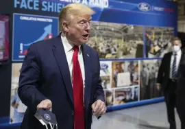  ?? aP ?? MAINTAINS CORE SUPPORT: President Trump holds his protective face mask as he speaks while touring Ford’s Rawsonvill­e Components Plant that has been converted to making personal protection and medical equipment, Thursday, in Ypsilanti, Mich.