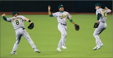  ?? ABBIE PARR — GETTY IMAGES ?? The A’s Robbie Grossman, from left, Ramon Laureano and Mark Canha celebrate their 3-2 win against the Seattle Mariners.