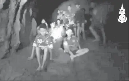  ?? THAI NAVY SEAL VIA AP ?? This image taken from a video made Monday shows the 12 boys and their soccer coach, who had been missing more than a week, sitting on a dry area inside a partially flooded cave.