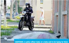  ??  ?? GUAYAQUIL: A police officer looks at a body said to be laying for three days outside a closed clinic in Guayaquil. — AFP