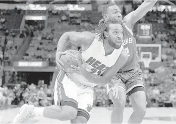  ?? MICHAEL LAUGHLIN/STAFF PHOTOGRAPH­ER ?? Miami’s Derrick Williams drives past the Bucks’ Jabari Parker during the first half Thursday at AmericanAi­lrlines Arena.