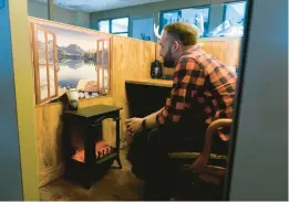  ?? MICHAEL NOBLE JR./THE NEW YORK TIMES ?? Lucas Mundt enjoys his cubicle, decorated as a cabin in the woods, Aug. 18 at Simple Modern in Oklahoma City, Oklahoma. Once derided as symbols of a commodifie­d workforce, cubicles are making a comeback.