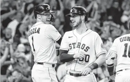  ?? Karen Warren / Staff photograph­er ?? Kyle Tucker (30) is met at home plate by Carlos Correa (1) after his three-run home run in Friday’s clincher. Tucker and Correa are both home-grown products who came up through the Astros’ farm system and helped them to a third World Series in five years.