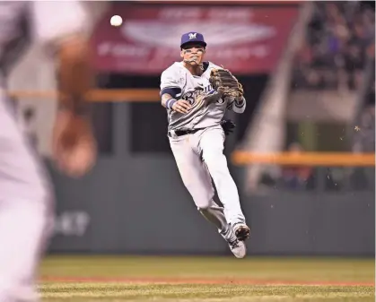  ?? RON CHENOY / USA TODAY SPORTS ?? Brewers shortstop Orlando Arcia throws to first in the fourth inning Friday night against the Rockies. Find game coverage, including the box score, at jsonline.com/brewers.