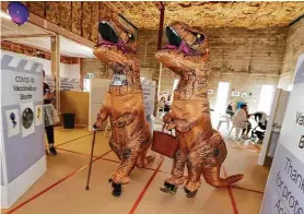  ?? Michael Cunningham / Associated Press ?? Allan and Patsy Beverwijka, dressed in dinosaur suits, arrive at a vaccinatio­n center Saturday in Whangarei, New Zealand.