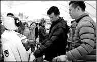  ?? CHAI HUA / CHINA DAILY ?? Passengers consult with a police robot at Shenzhen North Railway Station on Wednesday.