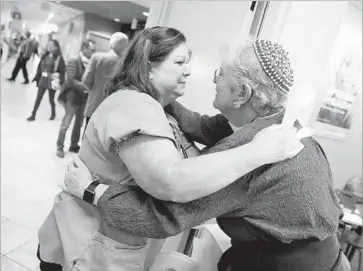  ?? BETH SCHLANKER The Press Democrat ?? SHELLY MATTHEWS, left, a licensed vocational nurse, and chaplain Meredith Cahn hug at a Kaiser Permanente medical clinic in Santa Rosa, where the wildfires’ sheer magnitude challenged emergency protocols.