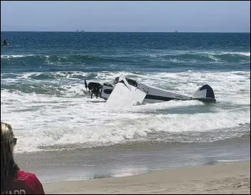  ?? ASSOCIATED PRESS ?? A small plane sits in the surf after it crashed into the ocean, Friday, just off Huntington Beach during a lifeguardi­ng competitio­n. A Coast Guard spokespers­on says the plane went down about 30 yards from shore and the pilot was rescued.
