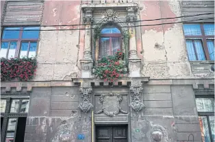  ??  ?? STILL SCARRED: Left, a row of damaged and destroyed buildings on Kotromanic­a Street in Sarajevo.