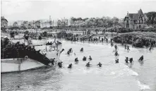  ?? NATIONAL ARCHIVES OF CANADA-GILBERT ALEXANDRE MILNE ?? Soldiers from the 9th Canadian Infantry Brigade land on a beach in Normandy, France, at Bernieres-sur-Mer on D-Day, June 6, 1944.