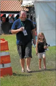  ?? GENE WALSH — DIGITAL FIRST MEDIA ?? Vendor Patrick McLaughlin takes a stroll with his daughter Rowan at the 56th annual Philadelph­ia Folk Festival in Upper Salford on Aug. 17.