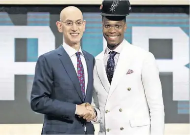  ?? KEVIN HAGEN/AP ?? NBA Commission­er Adam Silver poses with Lonnie Walker IV after the former Hurricanes standout was drafted by San Antonio.