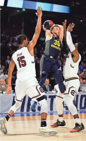  ?? GETTY IMAGES ?? Marquette guard Andrew Rowsey tries to pass out of a double team applied by South Carolina’s P.J. Dozier (left) and Duane Notice on Friday.