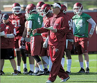  ?? NWA Democrat-Gazette/ANDY SHUPE ?? yells out instructio­ns during the team’s first day of spring drills Tuesday on the outdoor practice fields at the Fred W. Smith Center. The Razorbacks worked exclusivel­y in helmets and shorts as mandated by the NCAA and got a chance to work on their...