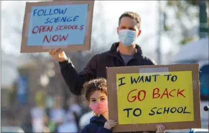  ?? ANDA CHU — STAFF ARCHIVES ?? Asaf Bar-tura and daughter Alma, 7, a first grader, protest along Solano Avenue near the Albany Unified School District Student Enrollment Center in Albany on Feb. 10. Parents and students held the demonstrat­ion to call for the reopening of schools.