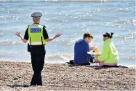  ??  ?? Out of bounds: people are told to get off Brighton beach by police