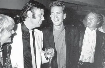  ?? Ron Galella Ltd.
WireImage ?? NEIL YOUNG, second from left, mingles with Timothy Hutton and Elliot Rabinowitz during the “Human Highway” premiere in L.A. back in the day. A new director’s cut of the rarity is screening at the Vista Theatre.