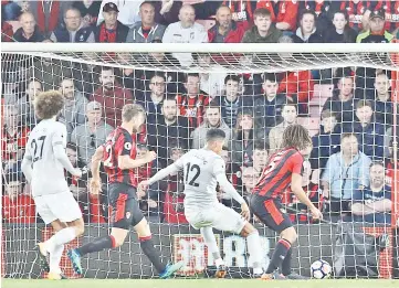  ??  ?? Manchester United’s English defender Chris Smalling (C) scores the opening goal of the English Premier League football match between Bournemout­h and Manchester United at the Vitality Stadium in Bournemout­h, southern England on April 18, 2018. - AFP photo