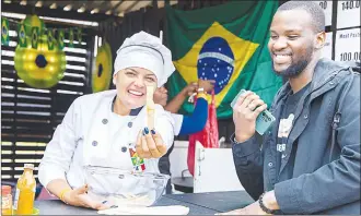  ?? ?? Vibrant chef of the day was Lucina Lauriano at her Pastel Brasileiro stall. Which served pastry snacks as she playfully showed us one of her homemade pastry gourmet sticks.