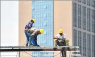  ?? MA JIAN / FOR CHINA DAILY ?? Constructi­on workers stand atop a property project in Zhengzhou, capital of Henan province.