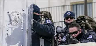  ??  ?? Armed guard: Capitol police officers, one with a paint gun, await the mob