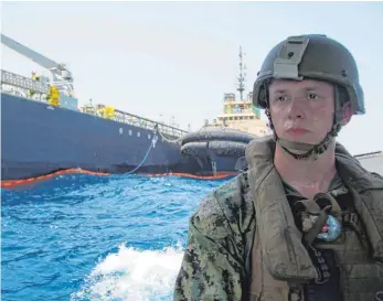  ?? FOTO: DPA ?? Ein Soldat der US-Marine steht vor dem beschädigt­en japanische­n Öltanker „Kokuka Courageous“– der von iranischen Angreifern beschädigt worden sein soll.