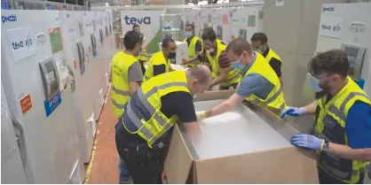  ?? (Alon Grego) ?? WORKERS PACK Pfizer vaccines for shipment to South Korea yesterday.