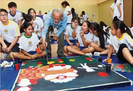  ?? — Photos: ART CHEN/ The Star. ?? Yusof is a true educator at heart. He is seen here helping students paint a mural during a recent visit to Beaconhous­e Sri Lethia Klang.