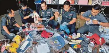  ?? ?? MOHD Khairi (dua dari kanan) melupuskan pelbagai barangan rampasan termasuk barangan tiruan di Stor Ekshibit Bukit Raja, semalam. - Gambar NSTP/FAIZ ANUAR