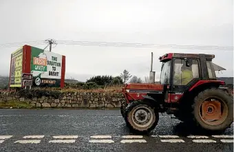  ?? AP ?? A farmer passes a billboard proposing a united Ireland as a solution to the complicati­ons caused by Brexit, at the border in Newry, Northern Ireland.