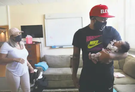  ?? Lea Suzuki / The Chronicle ?? Prentice Powell holds newborn Shai Powell as his wife, Sarai McCall, looks on. Data shows that Black men such as Prentice, in many aspects, are more attentive to the needs of their young children than fathers from other racial groups.