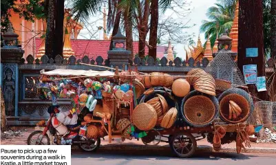  ??  ?? Pause to pick up a few souvenirs during a walk in Kratie, a little market town