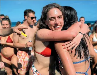  ?? AP ?? Two spring break revellers hug while partying in a large crowd on Pompano Beach, Florida, on Wednesday.