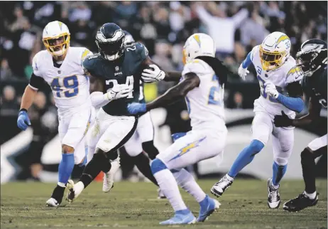  ?? AP PHOTO/MATT ROURKE ?? Philadelph­ia Eagles running back Jordan Howard (24) runs with the ball through Los Angeles Chargers defense during the first half of an NFL football game on Sunday in Philadelph­ia.