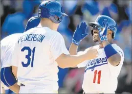  ?? Wally Skalij
Los Angeles Times ?? JIMMY ROLLINS (11) is greeted by Dodgers teammates, including Joc Pederson, after hitting a three-run home run in the eighth inning against San Diego.