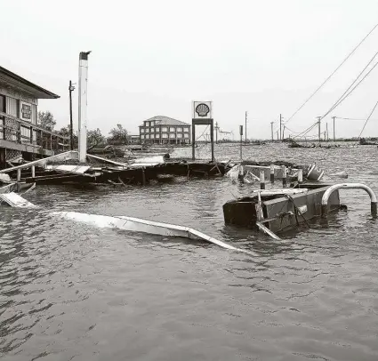  ?? David J. Phillip / Associated Press ?? Flooding inundates Cameron, La., on Aug. 28 after Hurricane Laura moved through the area. Back-to-back hurricanes shut more than 80 percent of offshore production at times.