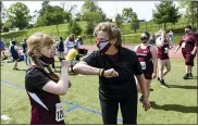  ?? BEN HASTY — MEDIANEWS GROUP ?? Pottsgrove athlete Abby Wilson gets an elbow bump from her coach Maria Steinmetz after running a race during a Special Olympics Unified Track Meet between Pottsgrove and Daniel Boone High Schools at Daniel Boone High School on Thursday.