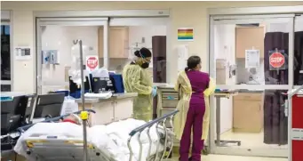  ?? ?? Health care workers put on new personal protective equipment in January at Roseland Community Hospital.