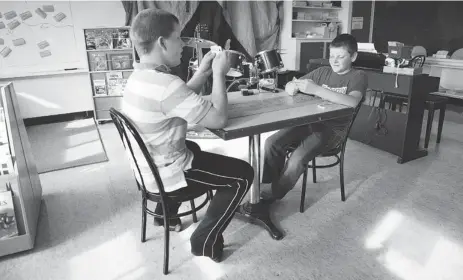  ?? PHOTOS: MONIQUE DYKSTRA SPECIAL TO THE GAZETTE ?? Entry Island School’s only students, Braiden Clarke, 13, and Logan Chenell, 11, play cribbage and converse en français during a French class last month. Clarke is in Grade 7, while Chenell is in Grade 6, but it isn’t clear whether the school will...