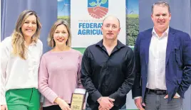  ?? JILLIAN FERGUSON • SPECIAL TO SALTWIRE ?? Keisha Rose Topic, left, president of the P.E.I. Federation of Agricultur­e, joins Agricultur­e Minister Bloyce Thompson, right, to present Heather and Gordon Mckenna of Bunny Burrow Vegetable Co. with the Hon. Gilbert Clements Award for 2023.