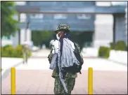  ?? (AP/Julio Cortez) ?? A midshipman wears a face mask to protect against covid-19 while walking with laundry.