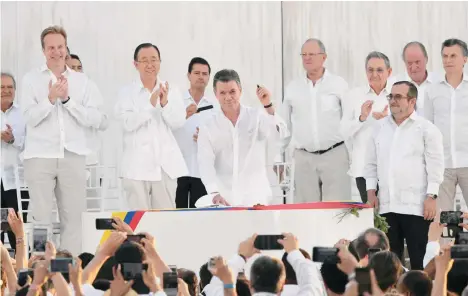  ?? GETTY IMAGES ?? El presidente Juan Manuel Santos y el líder de las FARC “Timochenko” firman el acuerdo de paz en Cartagena.