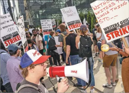  ?? ALEX KENT / GETTY IMAGES ?? Members and supporters of the Writers Guild of America form a picket line in New York City, the United States, on May 16. The strike kicked off on May 3, with writers demanding better pay.