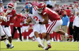  ?? Associated Press ?? Defense wins: Arkansas defensive lineman Julius Coates (13) tackles Mississipp­i quarterbac­k Matt Corral (2) for a loss during the first half Saturday in Fayettevil­le. The Razorbacks beat the Rebels 33-21.