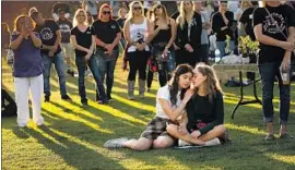  ?? Al Seib Los Angeles Times ?? LILLIAN BUCKINGHAM, left, and Jillian Spaeder, friends of a shooting victim, comfort each other Thursday during dedication services at the Healing Garden.