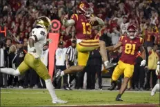  ?? MARK J. TERRILL — THE ASSOCIATED PRESS ?? Southern California quarterbac­k Caleb Williams jumps in for a touchdown beteween Notre Dame safety Xavier Watts and Southern California receiver Kyle Ford during the second half of Saturday’s game in Los Angeles.