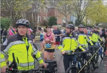  ?? JEAN MIKE REMY VIDEO SCREENSHOT ?? A group of Newton police officers with bicycles lined up at a running group’s spot last Marathon Monday, restrictin­g their cheering access to the road.